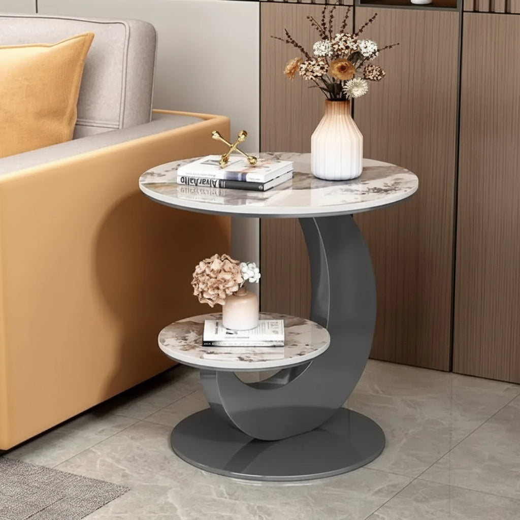 Modern side table with marble top and gray base in a living room setting.
