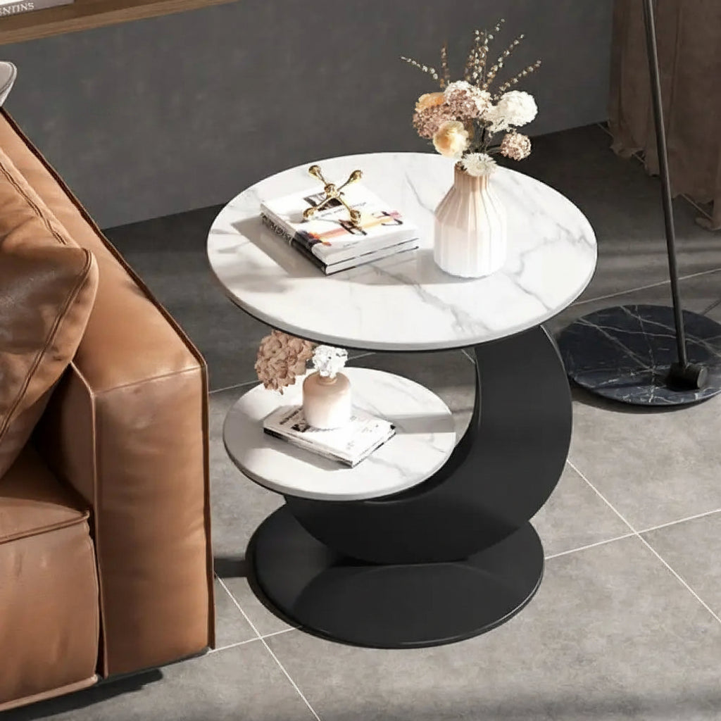 Modern side table with marble top and black base in a living room setting.

