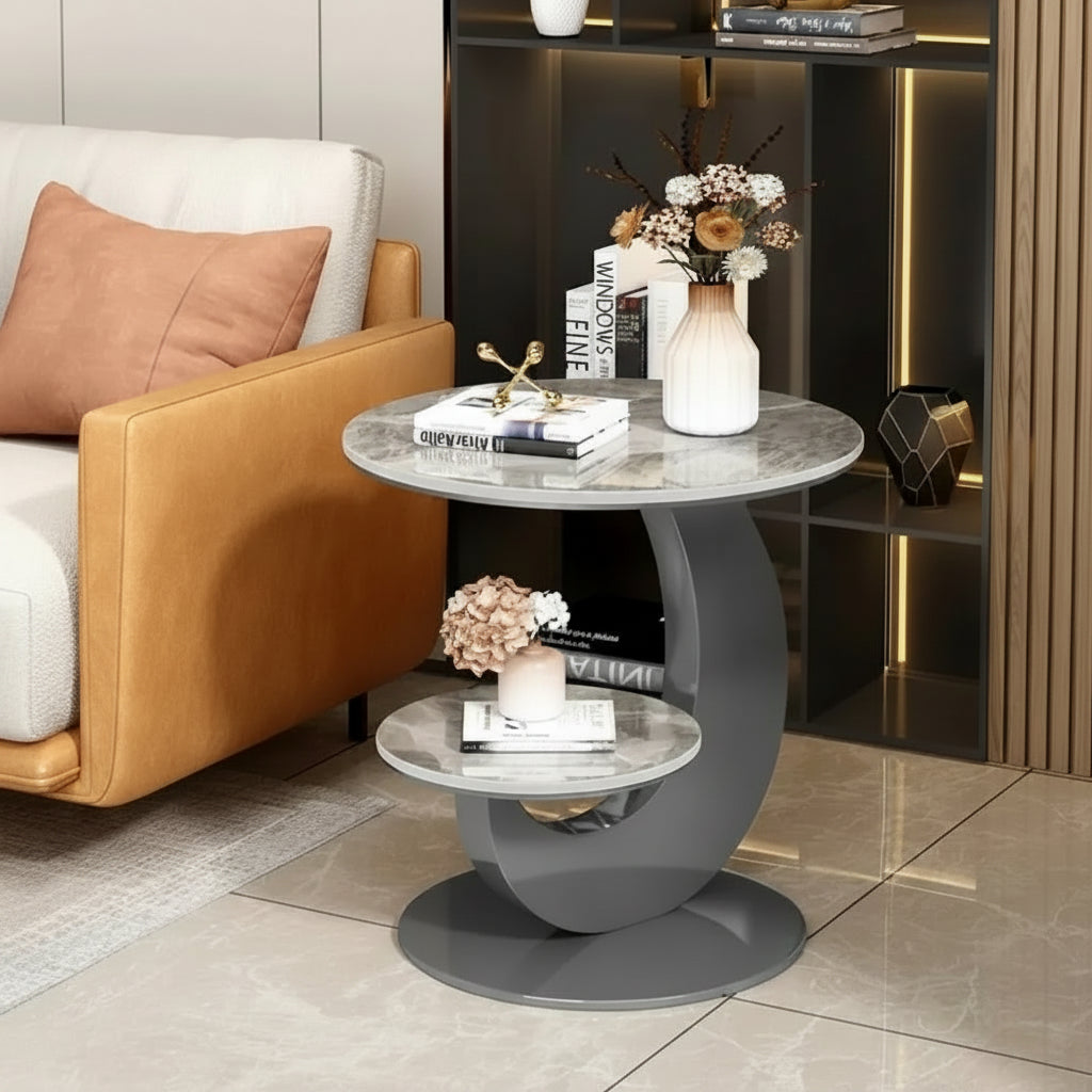 Modern side table with marble top and gray base in a living room setting.

